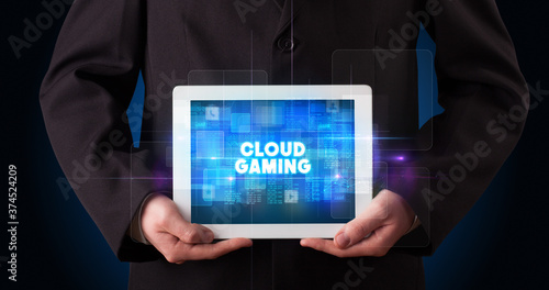 Wallpaper Mural Young business person working on tablet and shows the inscription: CLOUD GAMING Torontodigital.ca