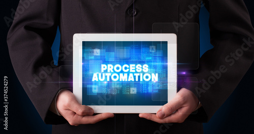 Wallpaper Mural Young business person working on tablet and shows the inscription: PROCESS AUTOMATION Torontodigital.ca