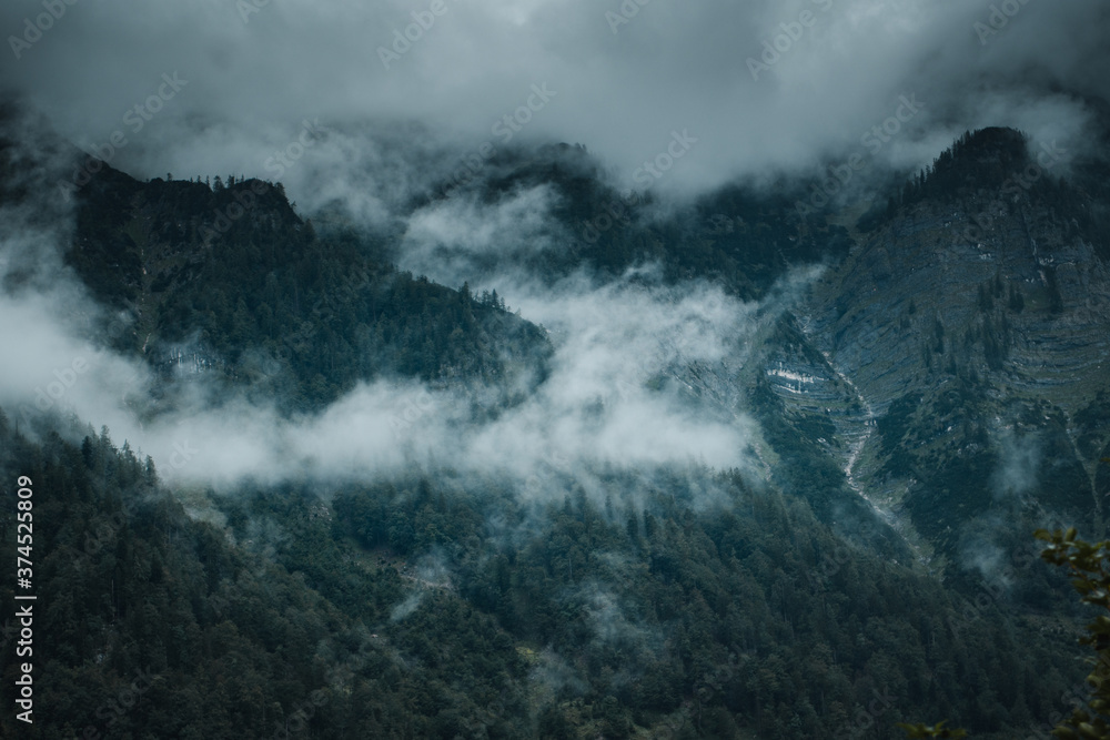 Moody dark foggy vibes with clouds in the mountain tops with moody weather in the austrian alps. Salkammergut in Austria, Europe, Alps