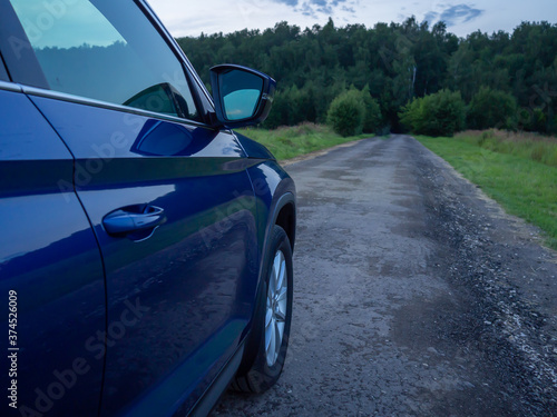 Close up rear-side view of blue car in nature background © Tani_Bel