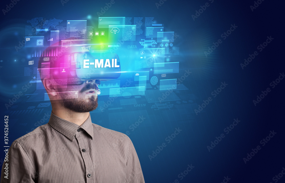 Businessman looking through Virtual Reality glasses with E-MAIL inscription, innovative security concept Businessman looking through Virtual Reality glasses with E-MAIL inscription, innovative security concept