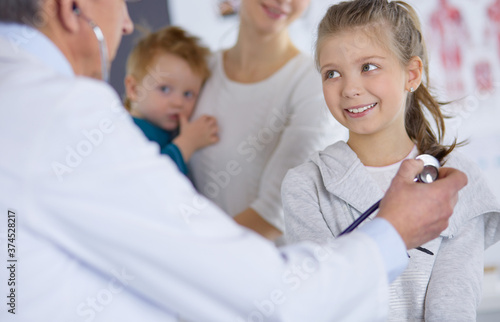 Girl and doctor with stethoscope listening to heartbeat