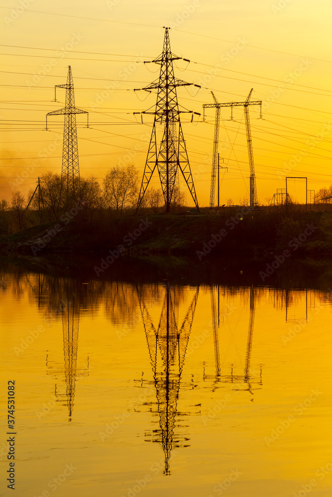 High-power line - power lines and the sunset reflected in the water