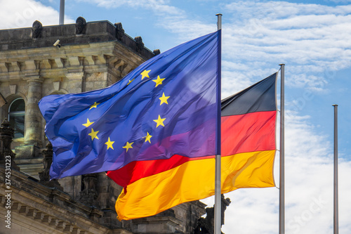 Foto Flaggen von Deutschland und der Europäischen Union wehen im Wind vor dem Reichstag in Berlin