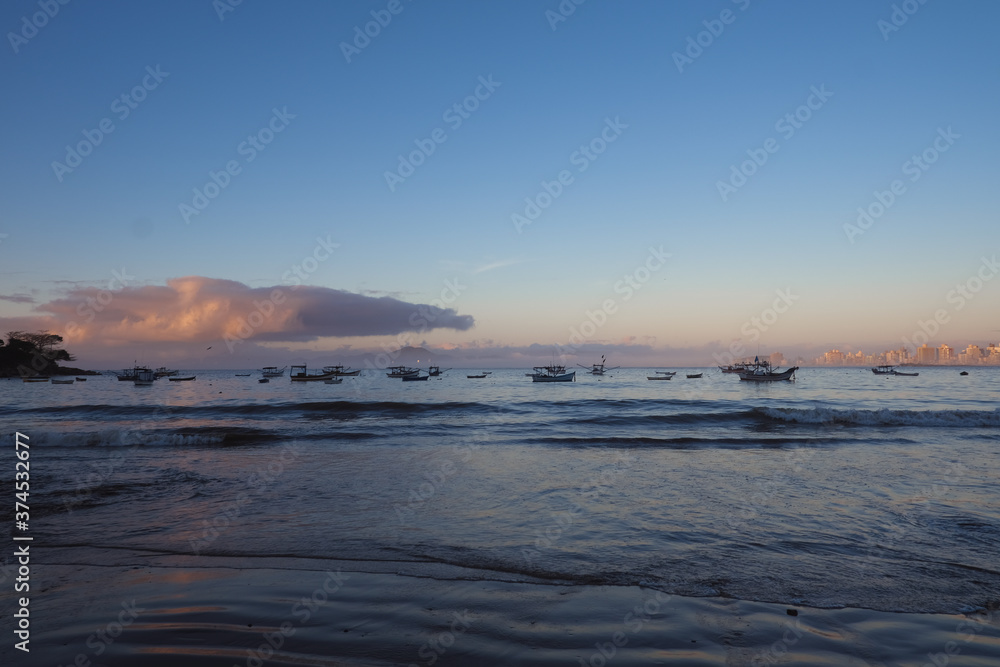 sunrise  on the beach with fishing boats 