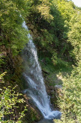 Beautiful mountain waterfall Gostilje in a green forest on natural park Zlatibor, Serbia in Europe on a sunny summer day
