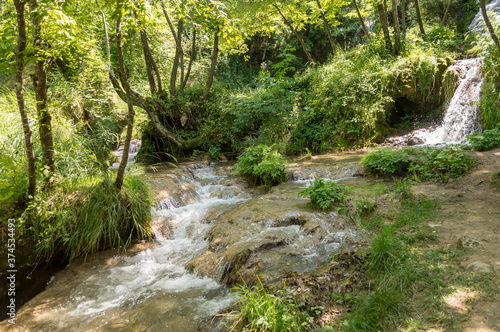 Beautiful mountain waterfall Gostilje in a green forest on natural park Zlatibor, Serbia in Europe on a sunny summer day