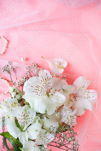 bouquet of white flowers on a pink background and space for text. wedding card. congratulation. invitation