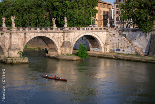  A crew team rows near a bridge on the Tiber River in Rome, Italy. © JAMES