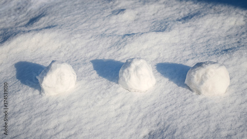 Snowballs in the snow in sunny weather, winter fun © Volodymyr