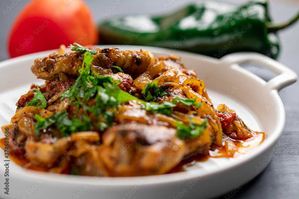 Spicy delicious chicken wings cooked with hot sauce and tomato with caramelized onions topped with chopped cilantro Spicy delicious chicken wings cooked with hot sauce and tomato with caramelized onions topped with chopped cilantro