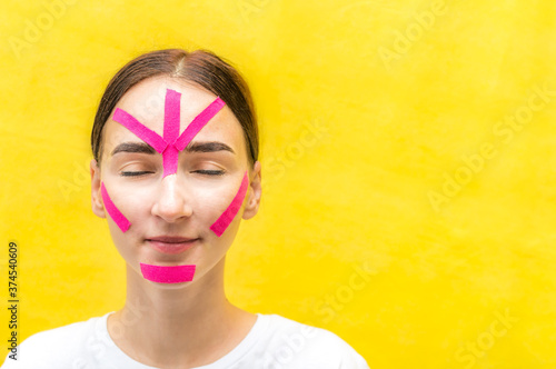 Portrait of a young woman with kinesio tapes on her face