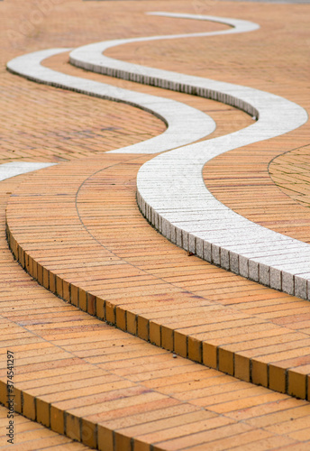 Abstract shapes found in a walking area in an apartment block in northern Lund, Skåne, Sweden. The shape is consisting of white and red bricks laid in an s-shaped pattern.