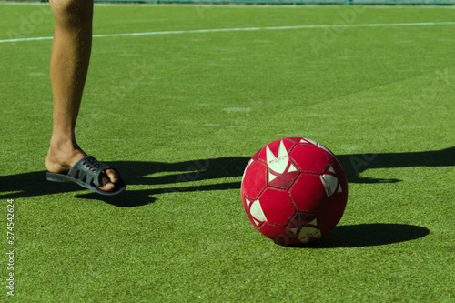 Fototapeta Naklejka Na Ścianę i Meble -  teenager feet playing with soccer ball on green field cover