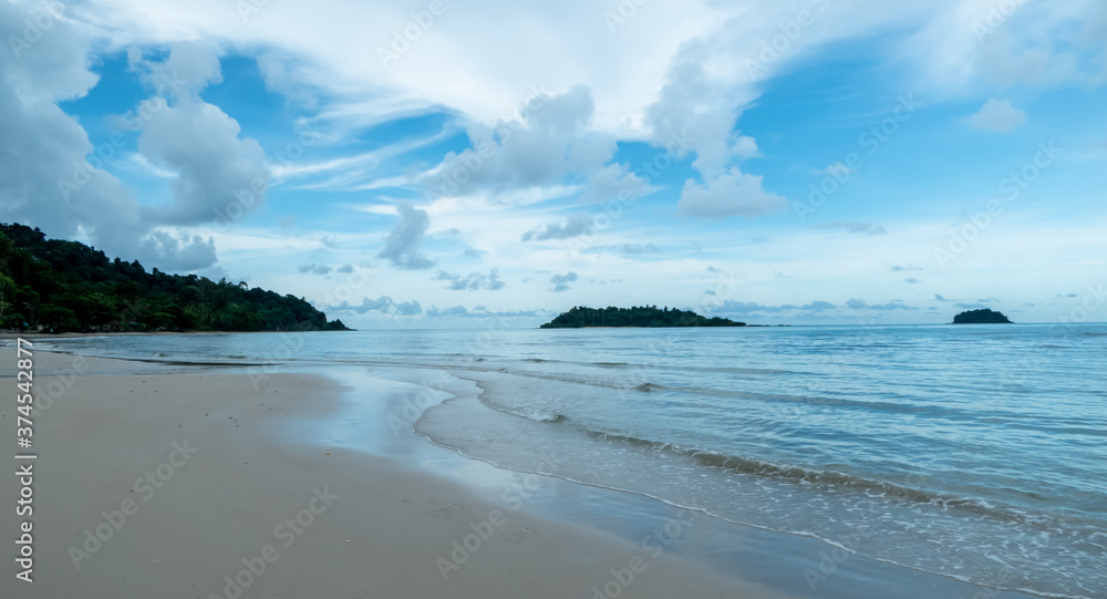 Quiet beach with blue sky with clouds floating in the sky.
