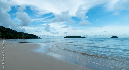 Quiet beach with blue sky with clouds floating in the sky.