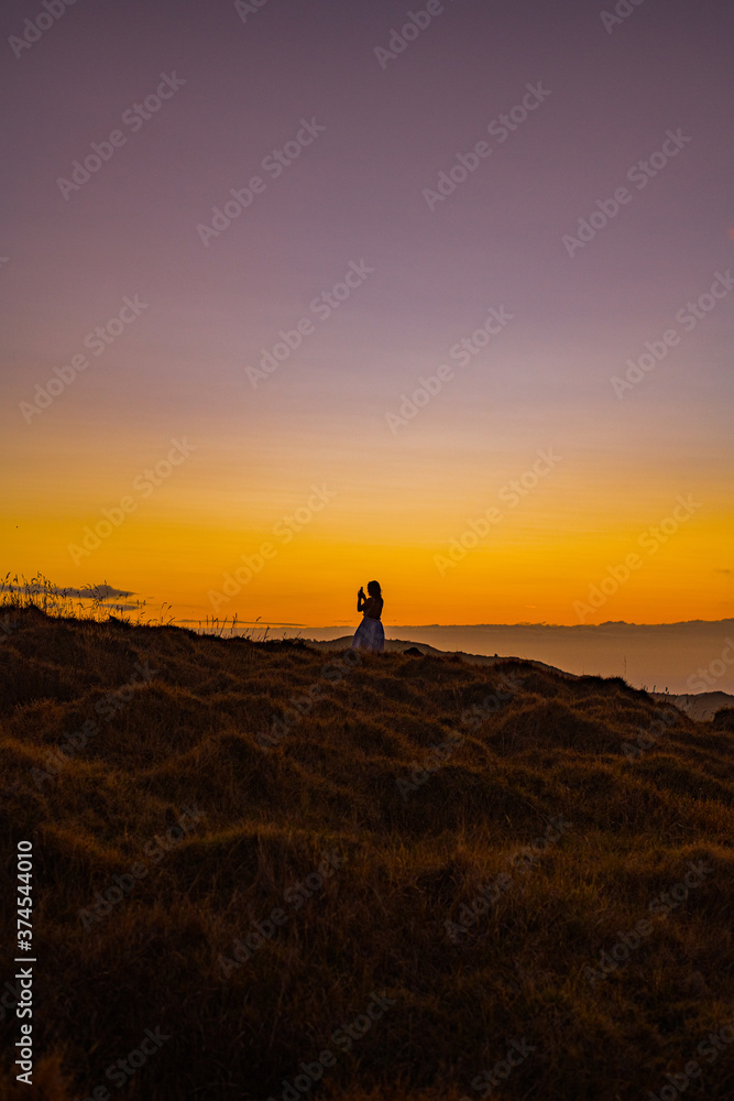 woman on a mountain at sunset