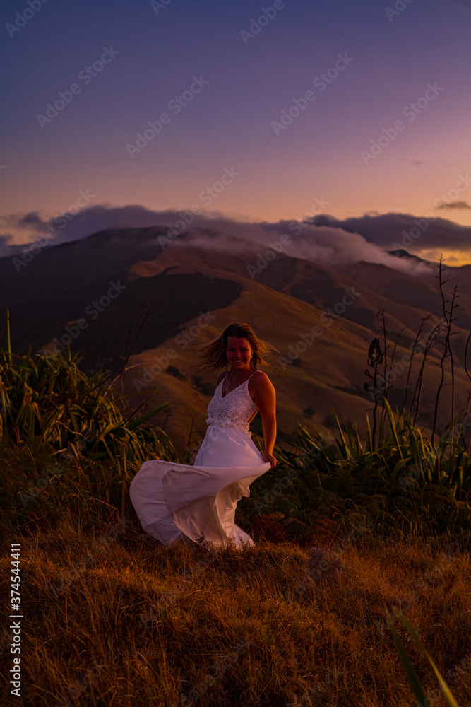 Naklejka premium woman on a mountain at sunset