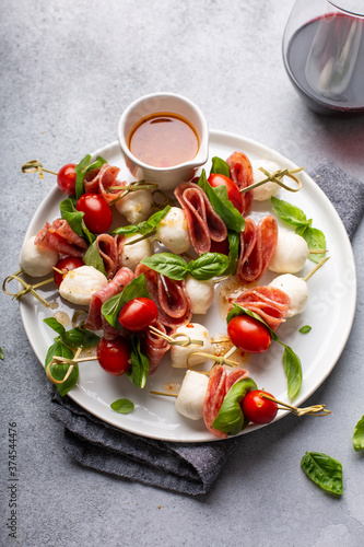 Canvas Print Appetizer antipasto skewers with tomatoes, salami, mozzarella and basil