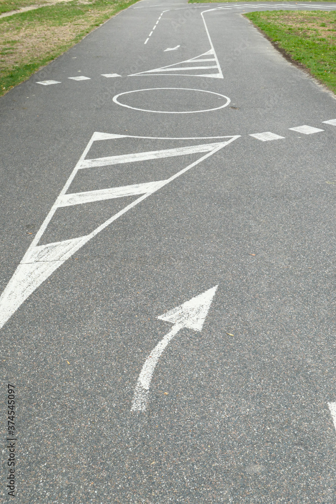 Fototapeta premium Ground marking with white paint. Driving track for bike or motorcycle. Road with direction symbol.