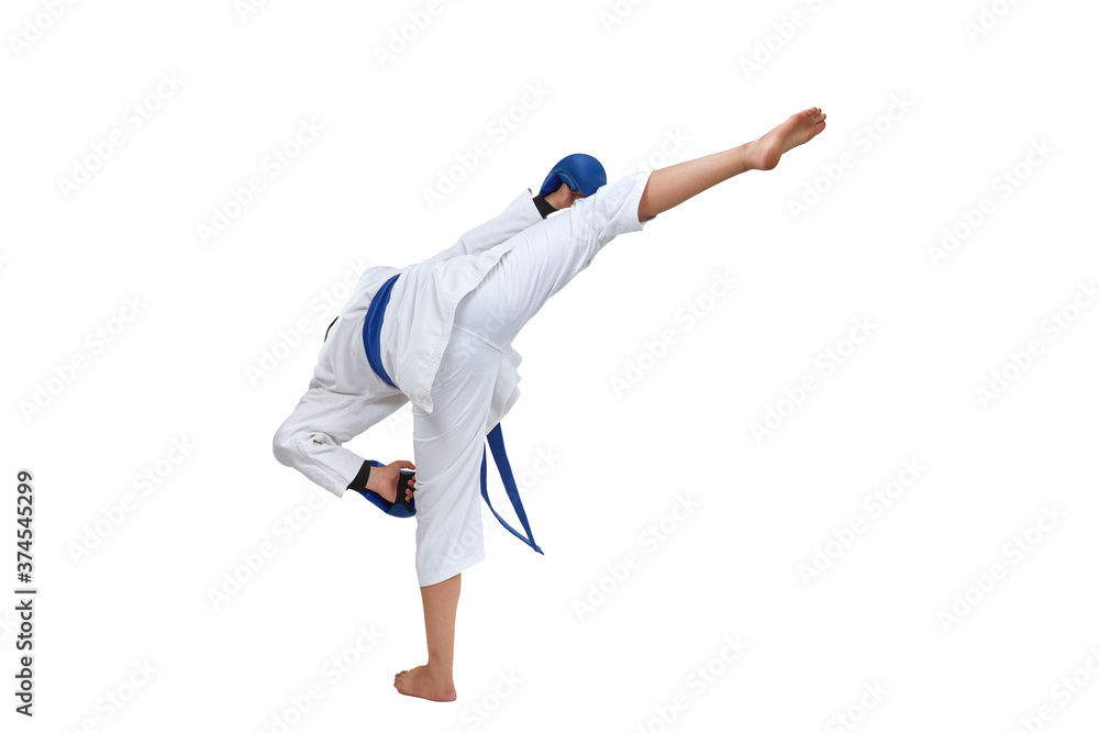 On white isolated background in karategi boy athlete performs a kick On white isolated background in karategi boy athlete performs a kick