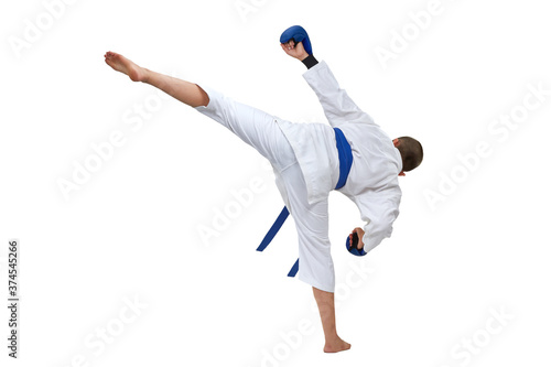 In karategi boy athlete performs a kick on white isolated background
