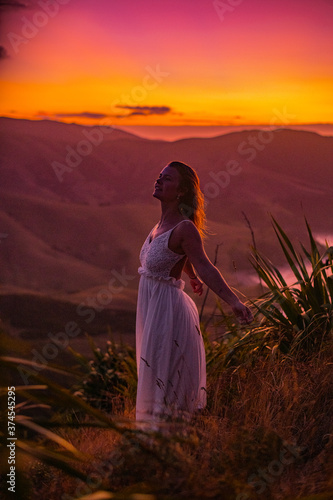 woman on top of a mountain at sunset