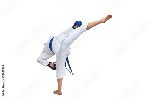 On white isolated background in karategi boy athlete performs a kick
