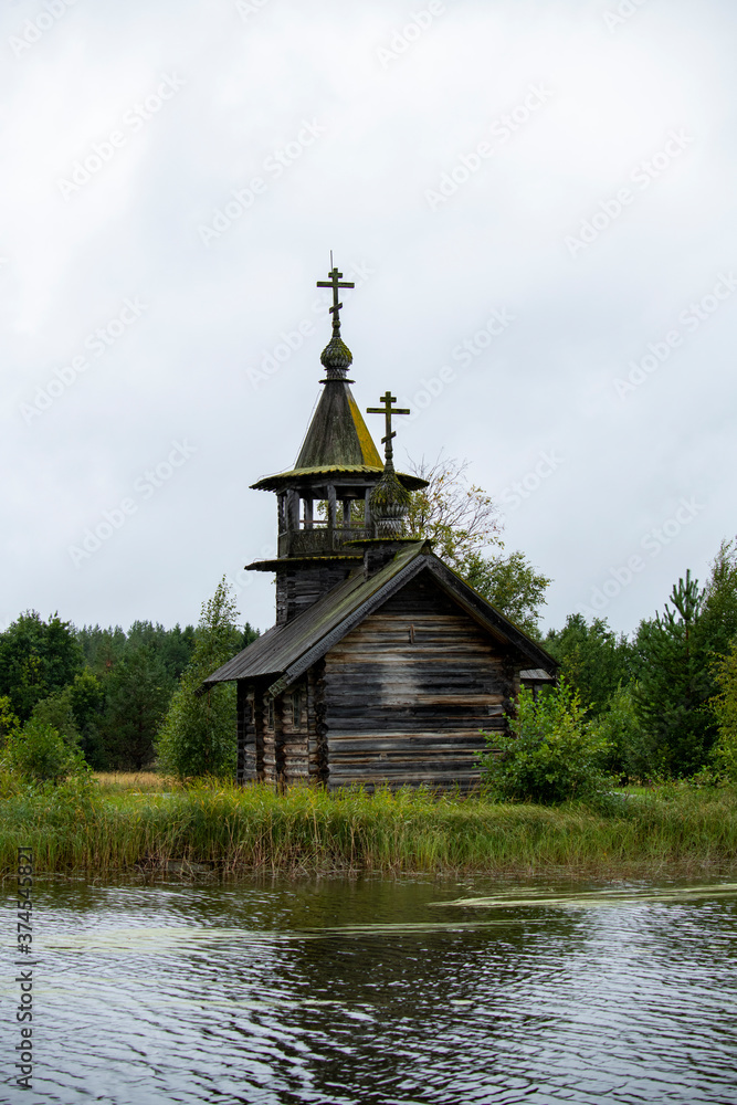 old wooden church on the island between trees in the rain old wooden church on the island between trees in the rain