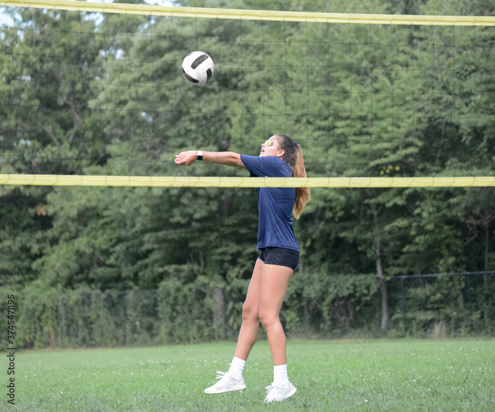 Volleyball player setting ball during outdoor grass game