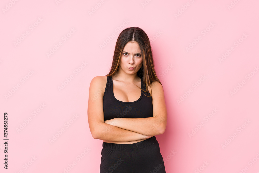 Young fitness caucasian woman isolated frowning face in displeasure, keeps arms folded. Young fitness caucasian woman isolated frowning face in displeasure, keeps arms folded.