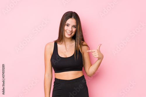 Young fitness caucasian woman isolated person pointing by hand to a shirt copy space  proud and confident