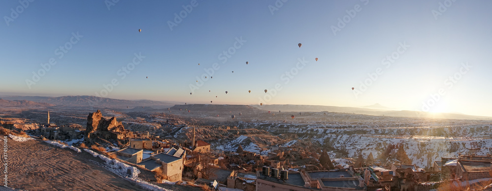 Hot Air Balloons rising in the sky during sunrise in Cappadocia in Göreme, Turkey.