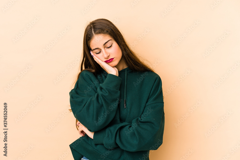 Young caucasian woman isolated en beige background who is bored, fatigued and need a relax day. Young caucasian woman isolated en beige background who is bored, fatigued and need a relax day.