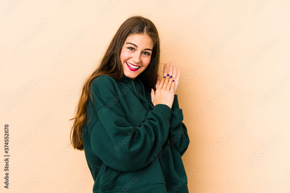 Young caucasian woman isolated en beige background feeling energetic and comfortable, rubbing hands confident. Young caucasian woman isolated en beige background feeling energetic and comfortable, rubbing hands confident.