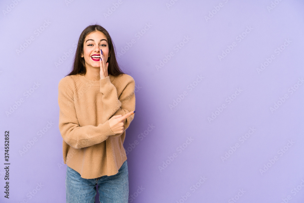 Young caucasian woman isolated on purple background saying a gossip, pointing to side reporting something. Young caucasian woman isolated on purple background saying a gossip, pointing to side reporting something.