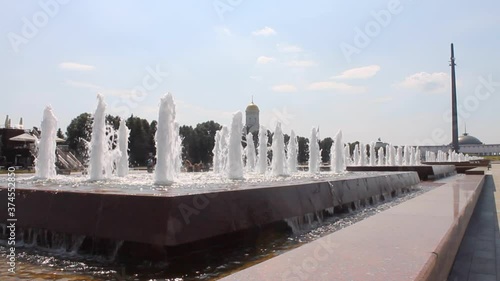 water fountain and view of the memorial spire on Poklonnaya hill in victory Park on a clear summer day in Moscow Russia