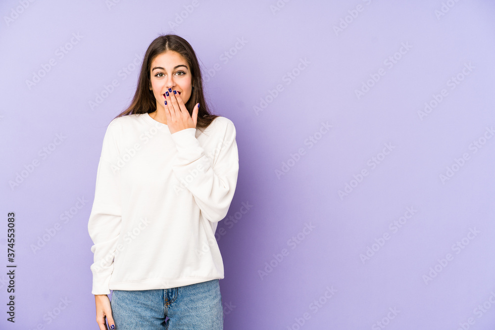Young caucasian woman isolated on purple background shocked, covering mouth with hands, anxious to discover something new. Young caucasian woman isolated on purple background shocked, covering mouth with hands, anxious to discover something new.