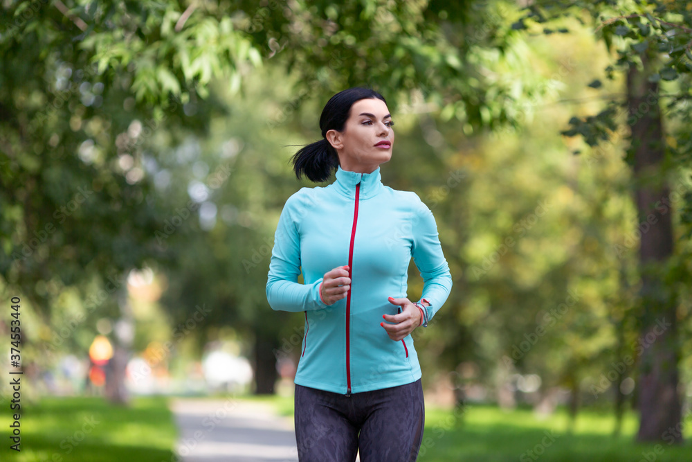 Female jogger is training in the park. Female jogger is training in the park.