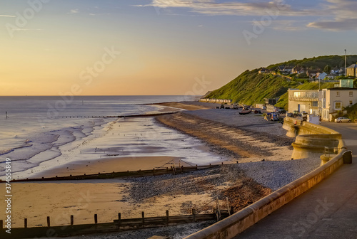 A view over Cromer beach and the promenade at sunrise. Captured from  high up on the wooden boardwalk of the Victorian pier. photo