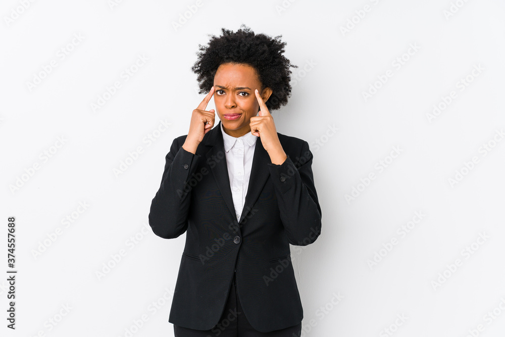 Middle aged african american business woman against a white background isolated focused on a task, keeping forefingers pointing head. Middle aged african american business woman against a white background isolated focused on a task, keeping forefingers pointing head.