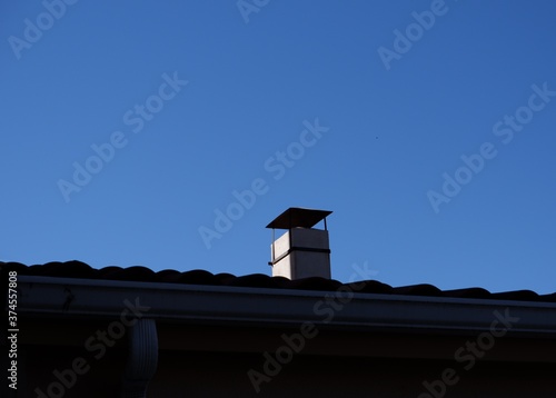 Chimenea en tejado con cielo azul