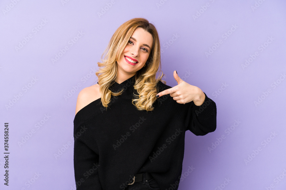 Young blonde woman isolated person pointing by hand to a shirt copy space, proud and confident Young blonde woman isolated person pointing by hand to a shirt copy space, proud and confident