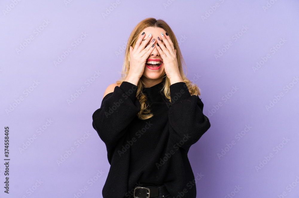 Young blonde woman isolated covers eyes with hands, smiles broadly waiting for a surprise. Young blonde woman isolated covers eyes with hands, smiles broadly waiting for a surprise.