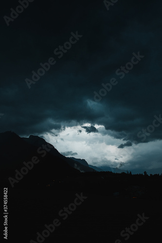 Heavy summer thunderstorm weather with moody dark vibes in the mountains with panorama landscape view and mountain silhouettes of the heavy rain. Austrian Alps, Salzkammergut in Austria, Europe