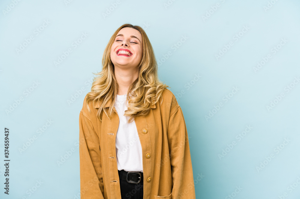 Young blonde pretty woman isolated relaxed and happy laughing, neck stretched showing teeth. Young blonde pretty woman isolated relaxed and happy laughing, neck stretched showing teeth.