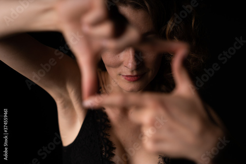Girl in black lace bra posing for the camera and makes hand window