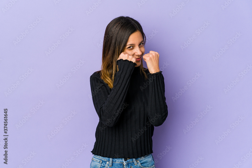 Young woman isolated on purple background throwing a punch, anger, fighting due to an argument, boxing. Young woman isolated on purple background throwing a punch, anger, fighting due to an argument, boxing.