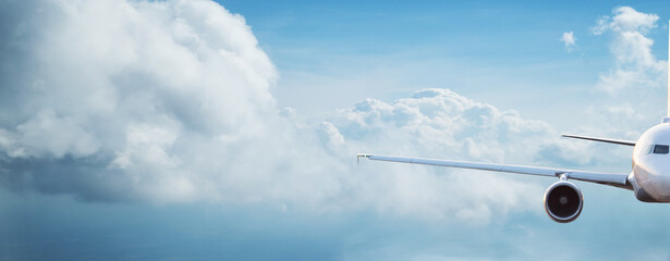 Commercial airplane jetliner flying above dramatic clouds in beautiful light. Travel concept.
