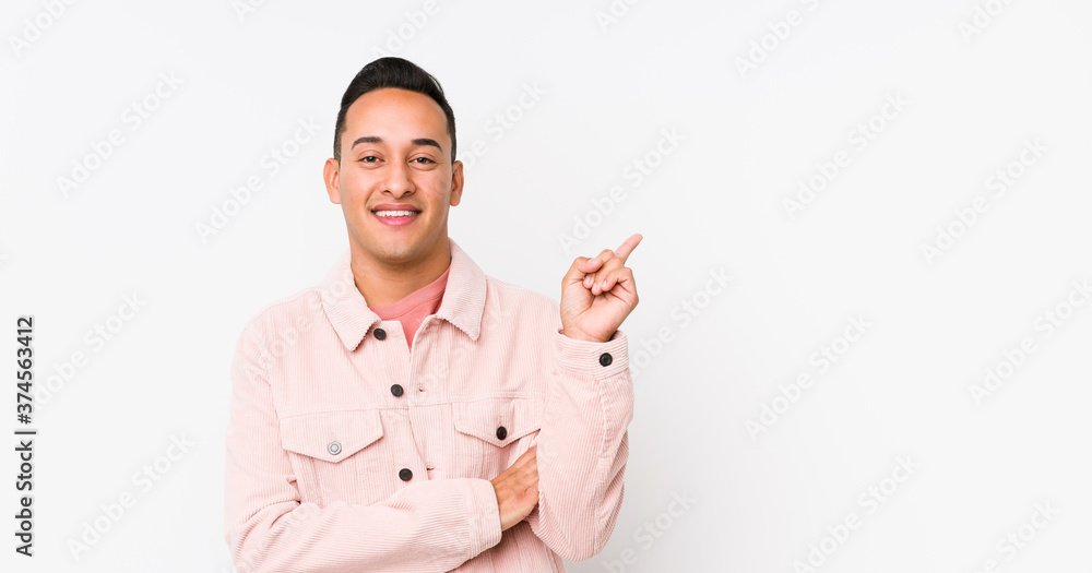 Young latin man posing isolated smiling cheerfully pointing with forefinger away. Young latin man posing isolated smiling cheerfully pointing with forefinger away.